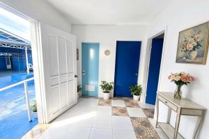 a hallway with blue doors and a table with flowers at B'lu Bamboo in Moalboal