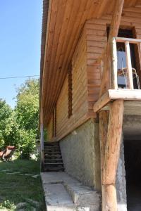 a wooden building with a staircase leading up to it at Keria in Ambrolauri +4 photos