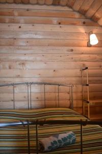 a bed in a room with a wooden wall at Keria in Ambrolauri