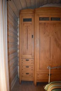 a bedroom with two wooden cabinets and a bed at Keria in Ambrolauri