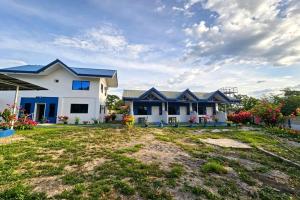 a white house with blue roofs and a yard at B'lu Bamboo in Moalboal