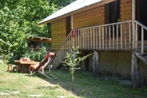 a cabin with a bench and a table in front of it at Keria in Ambrolauri