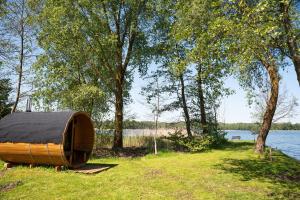 a wooden boat sitting on the grass near a body of water at Herrmanns-hof in Kronowo