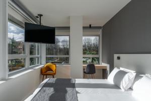 a bedroom with a bed with a flat screen tv at Hotel Distrito Oeste by Limehome in San Sebastián +49 photos