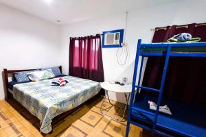 a bedroom with a bunk bed and a desk at B'lu Bamboo in Moalboal