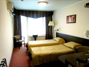 a hotel room with two beds and a window at Hotel Mirniy Resort in Odesa