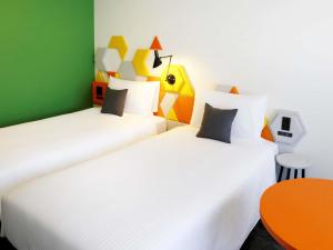 two beds in a room with green and white at ibis Styles Tokyo Bay in Urayasu