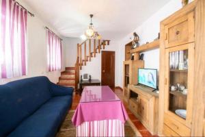 a living room with a blue couch and a table at Casa Rural Mi Medina in Medina Sidonia