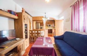 a living room with a blue couch and a table at Casa Rural Mi Medina in Medina Sidonia