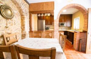 a kitchen with a table and a brick wall at Casa Rural Mi Medina in Medina Sidonia