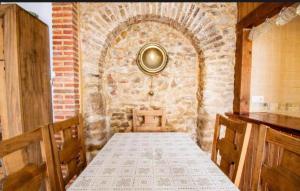 a dining room with a table and a brick wall at Casa Rural Mi Medina in Medina Sidonia +17 photos