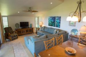 uma sala de estar com um sofá azul e uma mesa em Wailea Ekolu 1706 em Wailea