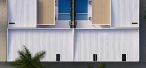 a building with white doors and a palm tree at The Sultanate Fulhadhoo Baa Atoll in Fulhadhoo