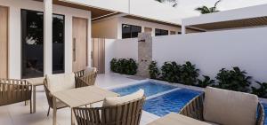 a patio with a table and chairs and a swimming pool at The Sultanate Fulhadhoo Baa Atoll in Fulhadhoo