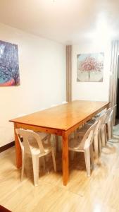 a wooden table with white chairs and a wooden table at Ysamatti Travel Lodge in Bankal +4 photos