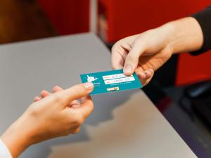 a person handing another person a credit card at Hotel F1 Maurepas in Maurepas