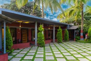a house with a courtyard and palm trees at Green View Resorts in Munnar