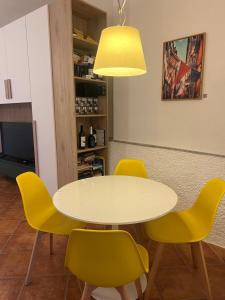 a table and yellow chairs in a room at Olivetta House Holiday in Moneglia