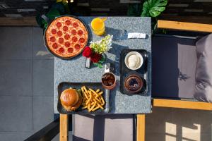 a table with a plate of pizza and french fries at Premium Pyramids BoutiQue With Rooftop Access in Cairo +144 photos