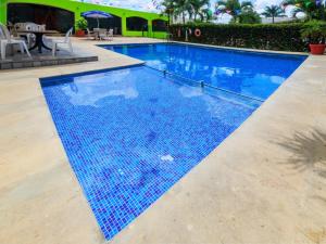 a swimming pool with blue tiles on the floor at Collection O Paris FC Express, Poza Rica de Hidalgo in Poza Rica de Hidalgo