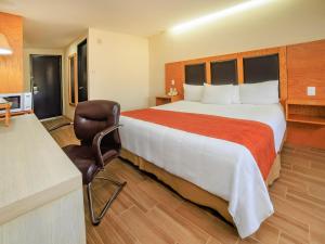 a hotel room with a large bed and a chair at Collection O Paris FC Express, Poza Rica de Hidalgo in Poza Rica de Hidalgo