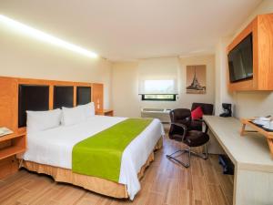 a hotel room with a large bed and a television at Collection O Paris FC Express, Poza Rica de Hidalgo in Poza Rica de Hidalgo