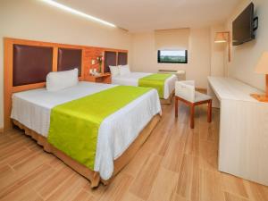 a hotel room with two beds and a television at Collection O Paris FC Express, Poza Rica de Hidalgo in Poza Rica de Hidalgo +34 photos