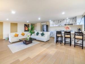 a living room with a white couch and a kitchen at Collection O Paris FC Express, Poza Rica de Hidalgo in Poza Rica de Hidalgo