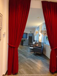 a living room with red curtains and a couch at Hotel Stadt Tuttlingen in Tuttlingen