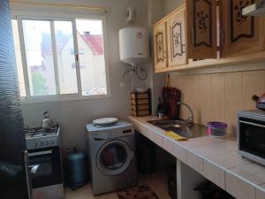 a kitchen with a washing machine and a sink at Bonnes vacances in Ifrane