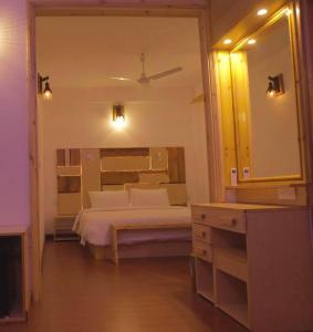 a bedroom with a bed and a large mirror at The Sultanate Courtyard Lh Hinnavaru 