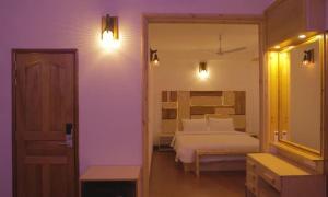 a bedroom with a bed and a room with a mirror at The Sultanate Courtyard Lh Hinnavaru 