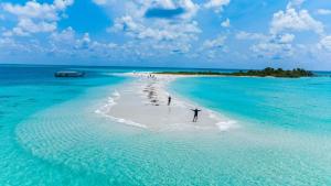 a group of people standing on a beach in the ocean at The Sultanate Courtyard Lh Hinnavaru 
