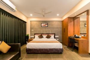 a hotel room with a bed and a desk at Neelagiri Heritage Hotel - Near Calicut Railway Station in Kozhikode