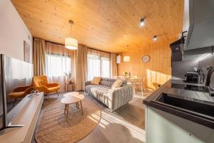 a living room with a couch and a kitchen at Muhu Apartments in Velké Hamry