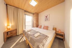 a bedroom with a large bed and a window at Muhu Apartments in Velké Hamry
