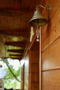 a bell hanging on the side of a wooden wall at Pod Dzwonkiem in Jasienica