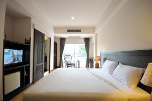 a hotel room with a bed and a television at Kasemsarn Hotel Chanthaburi in Chanthaburi