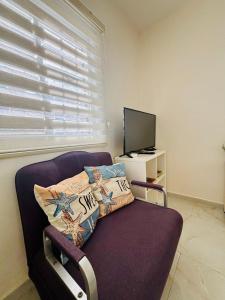 a living room with a couch and a television at Beachfront Studio, fully equipped in Netanya