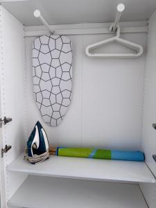 a white closet with a shelf and a mirror at Sunhaus in Gdynia