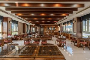 a restaurant with tables and chairs and windows at 聽風會館 in Yuanshan
