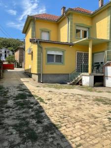 a yellow house with a driveway in front of it at Yellow House in Ritopek
