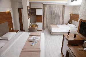 a large hotel room with two beds and towels at FAVORİTE Hotel in Söğütlü +8 photos
