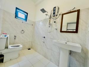 a bathroom with a toilet and a sink and a mirror at Rekawa Turtle Gate Hotel in Tangalle +73 photos