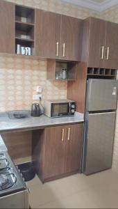 a kitchen with a counter with a microwave and a refrigerator at Jeks Apartments Limited in Ogbunike