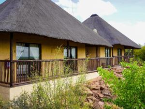 two thatched cottages with a thatched roof at Lucca Lodge in Linton
