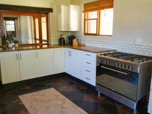 a kitchen with white cabinets and a stove top oven at Lucca Lodge in Linton
