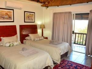 a bedroom with two beds and a balcony at Lucca Lodge in Linton +44 photos