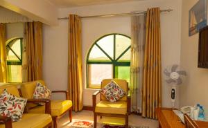a living room with two chairs and a window at Comfy Inn Hotel in Eldoret