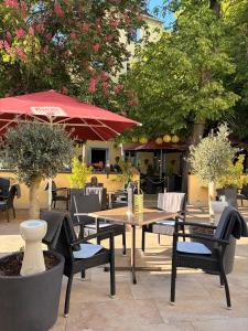an outdoor patio with tables and chairs and trees at Posthotel Arnold in Gunzenhausen
